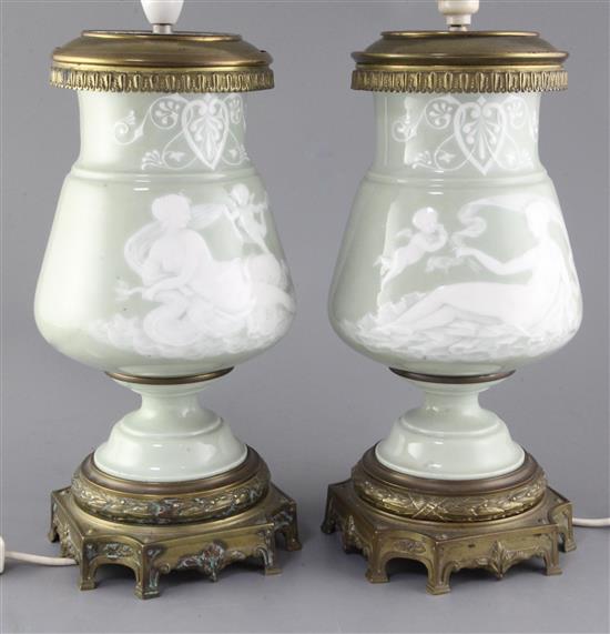 A pair of Paris porcelain pate-sur-pate celadon ground and ormolu mounted lamp bases